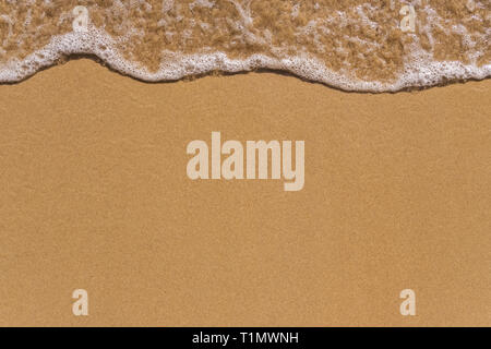 Wave on the sand beach background close up Stock Photo