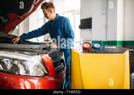 Mechanic checks air conditioning system in car Stock Photo
