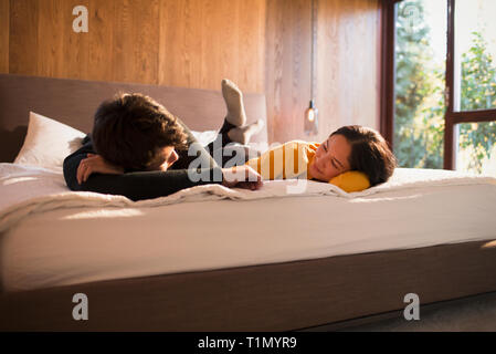 Couple laying on bed talking Stock Photo