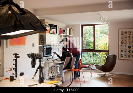 Photographers working at computer in studio Stock Photo