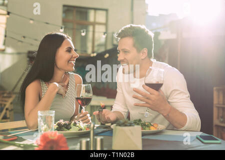Positive good-looking couple having active conversation while laughing Stock Photo