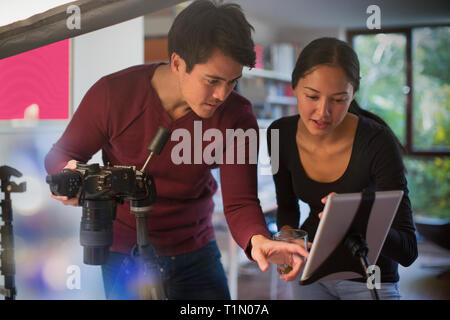 Photographers using digital tablet and camera in studio Stock Photo