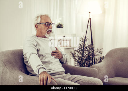 A septuagenarian grey-haired mister trying to control his heartrate Stock Photo