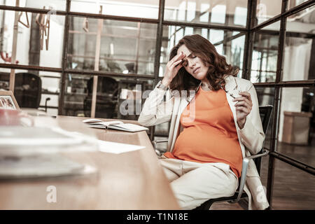 Disturbed long-haired woman being in hard emotional and physical condition Stock Photo