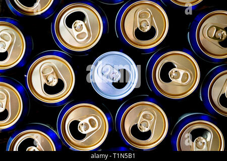 Abstract pattern of opened aluminium cans, top view. One white soda or beer can standing out among yellow and blue cans. Excess drinking, consumerism, Stock Photo