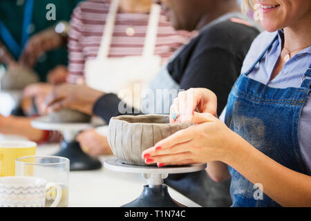 Woman making bowl in pottery class Stock Photo