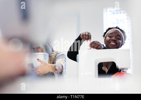 Smiling female fashion designer working at sewing machine Stock Photo