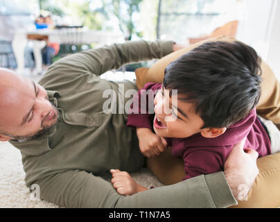 Playful father and son on floor Stock Photo