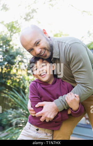 Portrait happy father and son hugging Stock Photo