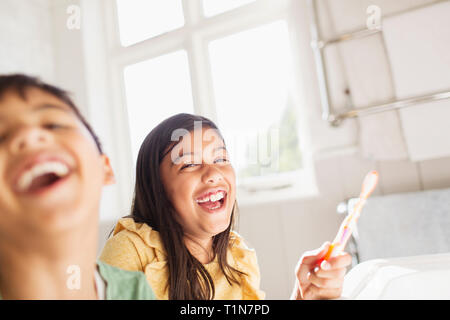 Portrait laughing brother and sister brushing teeth in bathroom Stock Photo