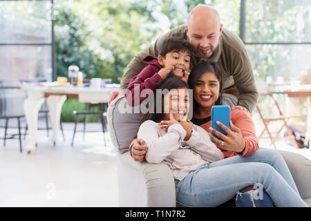 Playful family taking selfie with camera phone Stock Photo