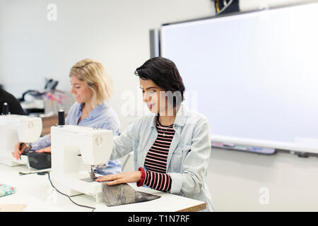Woman using sewing machine in sewing class Stock Photo