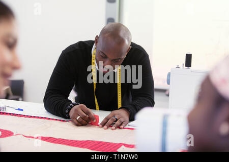 Focused male fashion designer marking sewing pattern Stock Photo