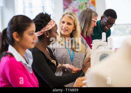 Fashion designers talking, working at sewing machines Stock Photo