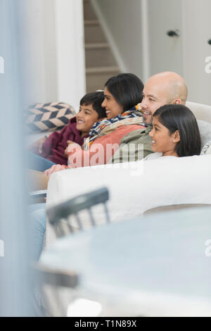 Family watching TV on living room sofa Stock Photo