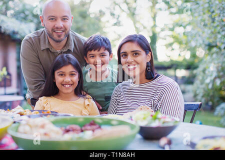 Portrait happy family eating lunch at table Stock Photo
