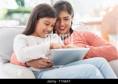 Happy mother and daughter using digital tablet Stock Photo