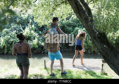 Family on dock at remote stream Stock Photo