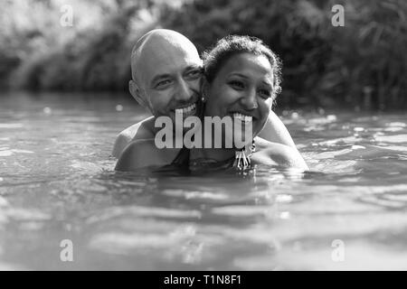 Happy couple swimming in river Stock Photo