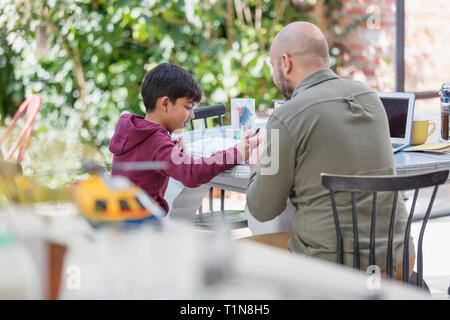 Father and son coloring at table Stock Photo