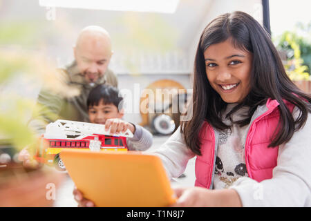 Portrait happy girl using digital tablet Stock Photo