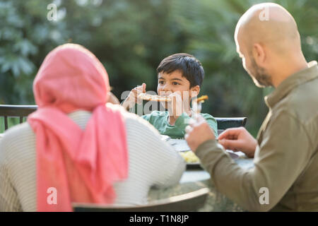 Family eating dinner at patio table Stock Photo