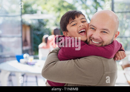 Happy, exuberant father and son hugging Stock Photo