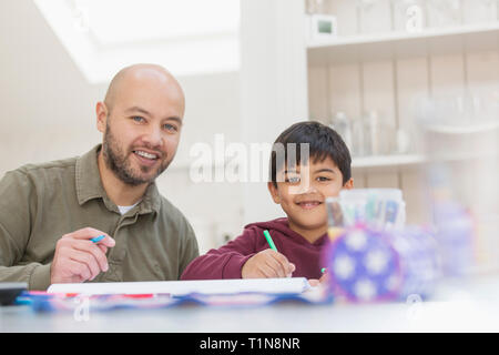 Portrait happy father and son coloring at table Stock Photo