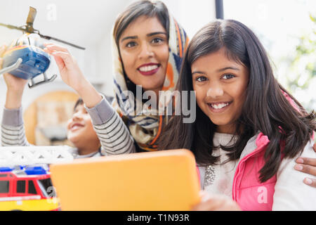 Portrait happy mother and children playing and using digital tablet Stock Photo