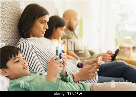 Family using technology on bed Stock Photo