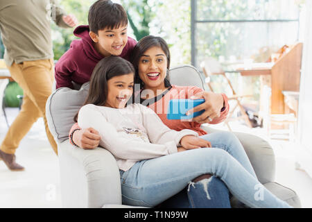 Mother and children taking selfie with camera phone Stock Photo