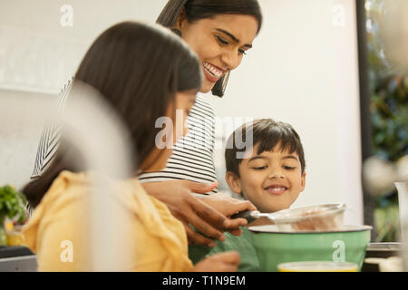 Mother and children baking in kitchen Stock Photo