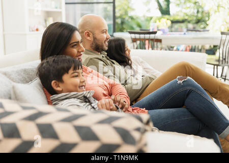 Family watching TV on living room sofa Stock Photo