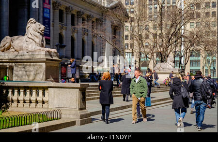 People walk in front of New York City Public Library  main branch & sit on steps at Fifth Ave. Midtown Manhattan New York City, USA. Mar 2018 Stock Photo