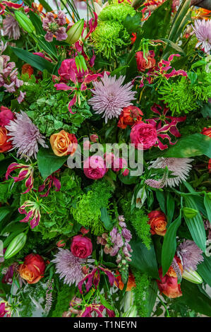Beautiful large bouquet of chrysanthemums, orchids and gerberas with a big yellow lily in a flower shop. Stock Photo