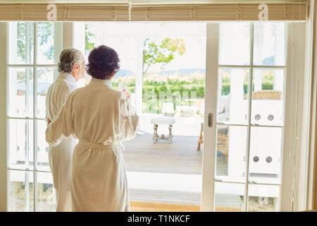 Mature couple in bathrobes at hotel patio doorway Stock Photo
