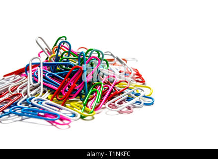 A lot of multi-colored stationery clips for documents lie on a white background. Close-up Stock Photo