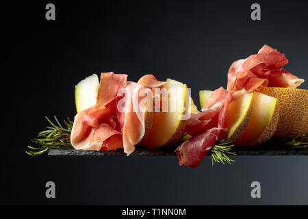 jamon with rosemary on a black background Stock Photo - Alamy