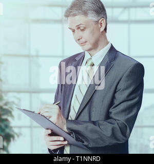 Businessman with documents and pen working the office. Stock Photo