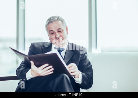 experienced lawyer reviews the documents with the terms of a new contract Stock Photo