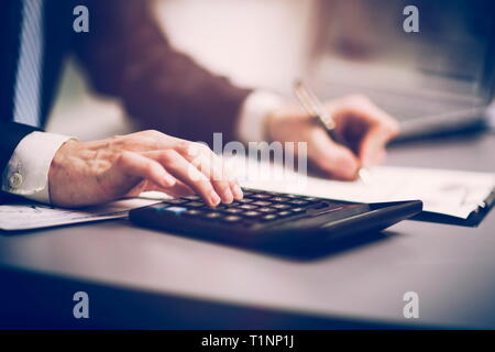 The businessman makes his own accounting, a financial report using a calculator Stock Photo