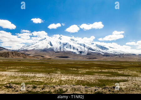 The majestic Muztagh Ata, 7546m, as seen from Karakorum Highway, Xinjiang, China. Connecting Kasghar to the Pakistan Border across the Pamir plateau,  Stock Photo