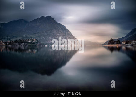 The mountains around Lecco reflected on the lake in a amazing cloudy day, Lombardy, Italy Stock Photo