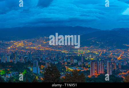 Cityscape of Medellin city at night (blue hour) with its modern skyscraper architecture located in a valley of the Andes mountain range, Colombia. Stock Photo
