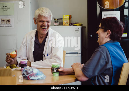 Factory workers in a canteen laughing while eating lunch in a Kent factory in the UK Stock Photo