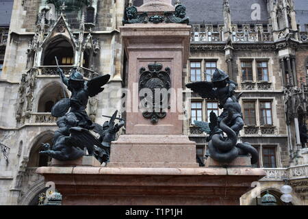 Two angle statues with shield and sword on a column in front of the munich city hall. Stock Photo