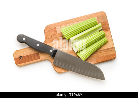 Celery sticks on cutting board. Cutting celery stalks and knife isolated on white background. Stock Photo