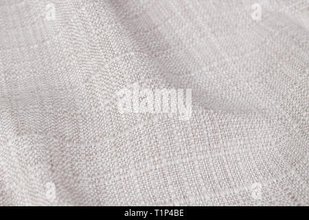 Crinkled woven textile. Grid pattern. Distinctive background in creamy color. Detail of decorative creased beige cloth. Abstract blank fabric close-up. Stock Photo