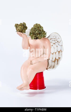 concept using a cherub with a broken head and replacing it with cannabis buds as a pot head in deep thought. Stock Photo