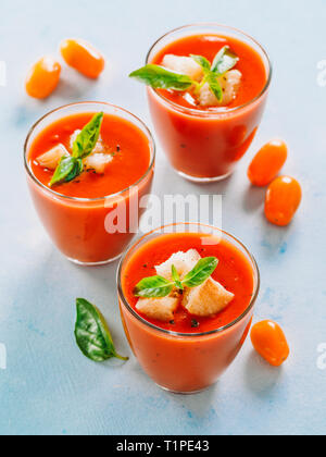 Delicious gaspacho soup in glass. Traditional spanish cold soup puree gaspacho or gazpacho on gray cement background. View from above or top view or flat lay. Vertical. Stock Photo